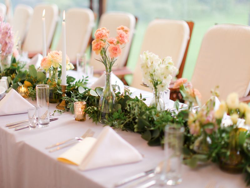stół przystrojony kwiatami na sali ślubnej